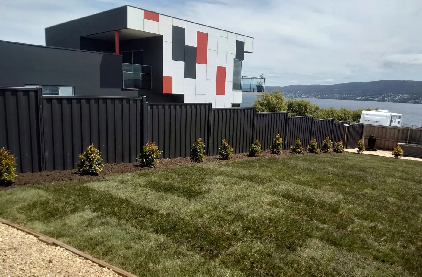 Finished lawn and dark fence overlooking the River Derwent