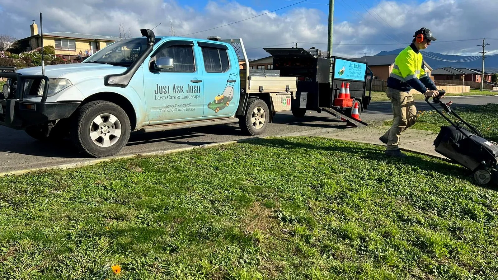Josh mowing beside the branded Just Ask Josh work truck